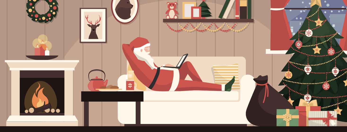 Santa sits on his couch reading his email, with a decorated tree and a full bag of presents at his feet