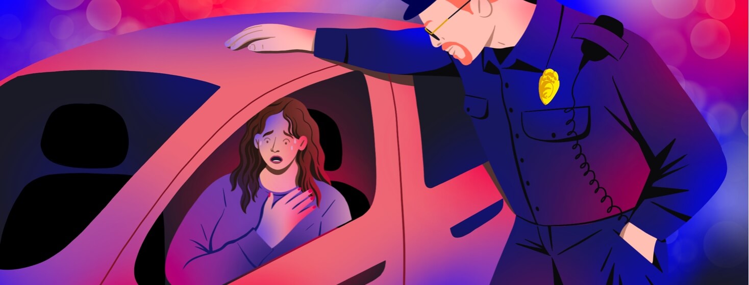 alt=a police officer leans over an open car window where a woman is holding her heart and panicking