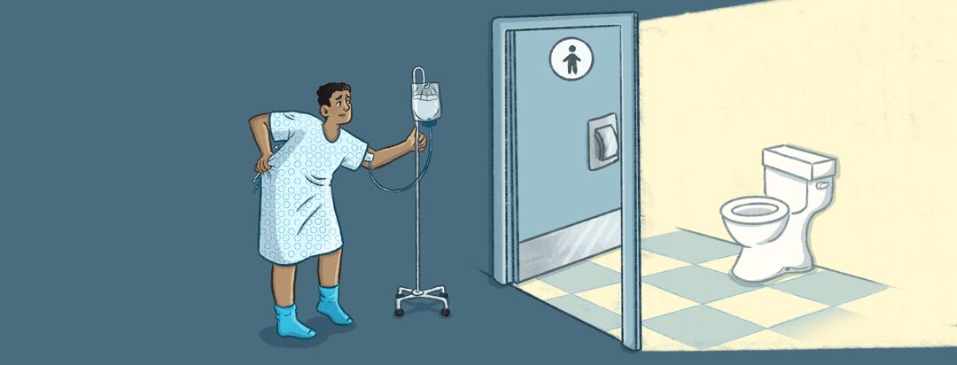 A man in a hospital gown walks toward the bathroom with his IV while holding his gown shut in the back